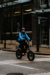 Helmeted rider commuting on an electric bicycle along a city street